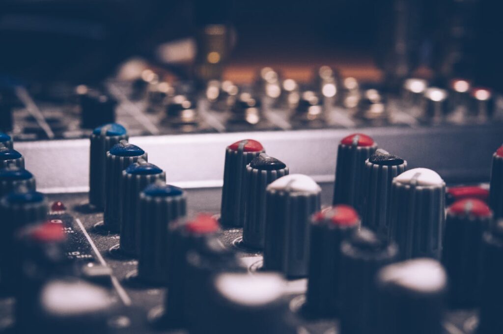 Close-up of audio mixer knobs in a dimly lit studio. Perfect for music and technology themes.